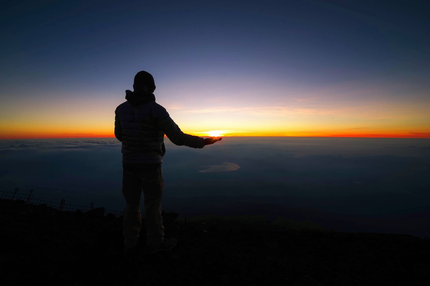 Hiker standing at sunrise, representing the journey toward clarity and growth